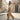 Femme portant un pantalon large en coton beige dans une rue européenne au soleil du matin