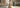 Femme portant un pantalon large en coton beige dans une rue européenne au soleil du matin