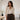 Photographie éditoriale de mode féminine premium, une femme adulte portant une tenue élégante aux tons naturels dans un atelier de confection sobre